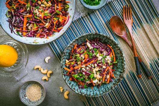 Red cabbage salad in Asian style with carrots, cilantro, cashew nuts and onions