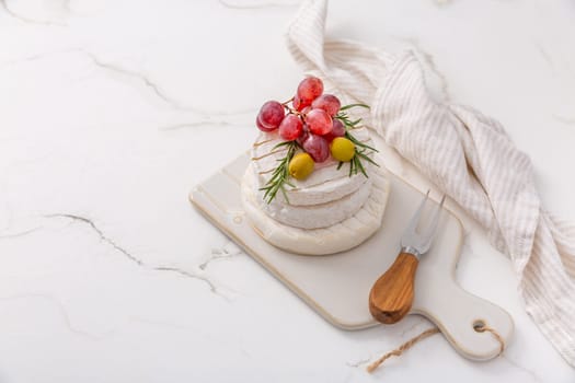 Cheese platter with French Camembert and Skyr cheese with grapes, olives and rose wine