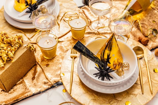 New Years Eve celebration. Holidays served table with champagne and and luxury golden cutlery, with decoration and Christmas decor