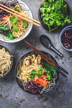 Vegan miso noodle soup with mushrooms, red cabbage, carrots and sprouts