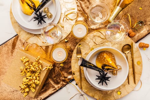 New Years Eve celebration. Holidays served table with champagne and and luxury golden cutlery, with decoration and Christmas decor