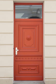 A decorated, red lacquered front door in front of a white background