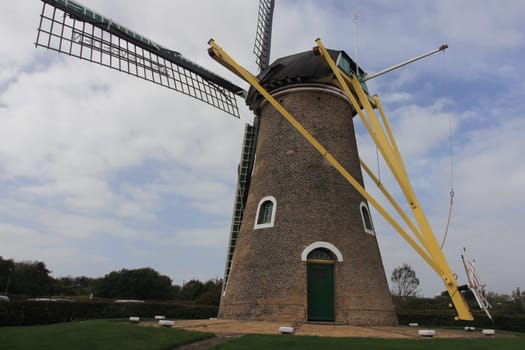A historic windmill with clouds and blue sky in the background