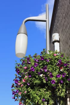 A flowered streetlight, blue sky in the background