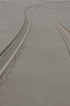 The fresh tire track of a vehicle in the wet sand