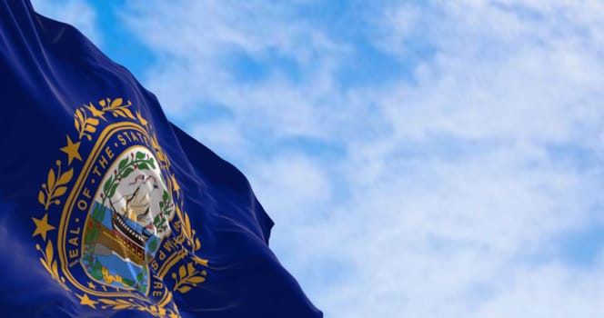 Close-up of New Hampshire state flag waving in the wind. Dark blue background with a state seal in the middle. 3d illustration render. Selective focus. Rippling fabric