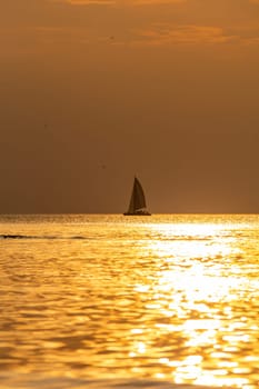 Beautiful orange sunset over the sea, a ship on the horizon