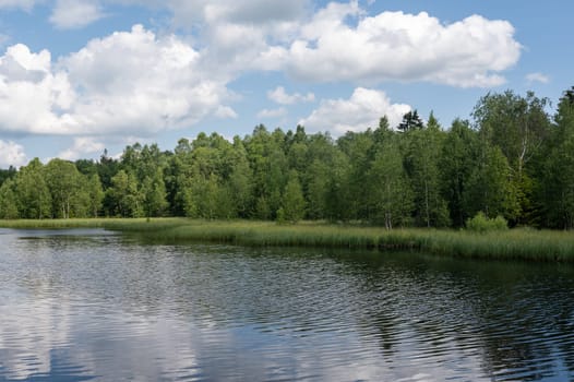 Reservoir at the red moor in the high Rhoen, Hesse, Germany. With blue sky and white clouds and reflection in the water