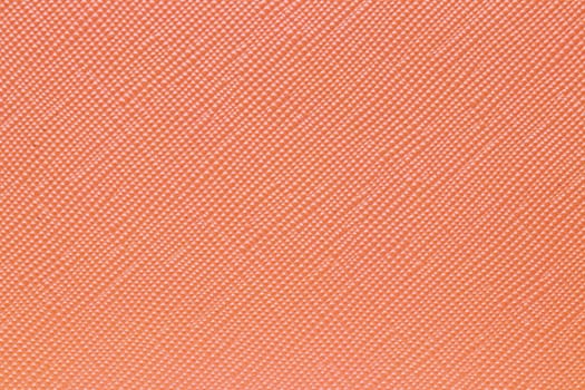 Seamless plastic texture background. Close-up of a detail from a orange surface of a cosmetic bag. Beautiful backdrop. Macro.