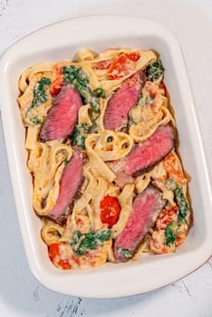 Creamy steak fettuccine pasta with spinach and tomatoes