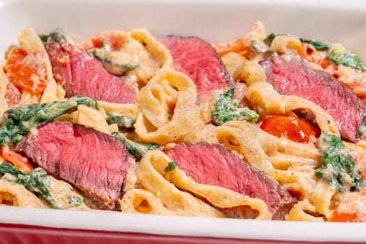 Creamy steak fettuccine pasta with spinach and tomatoes
