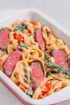 Creamy steak fettuccine pasta with spinach and tomatoes