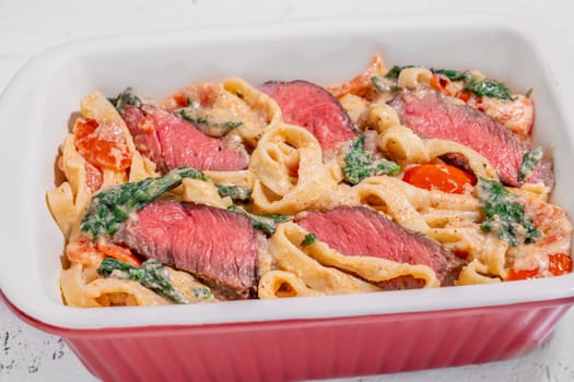 Creamy steak fettuccine pasta with spinach and tomatoes