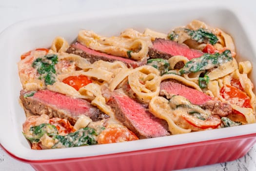 Creamy steak fettuccine pasta with spinach and tomatoes