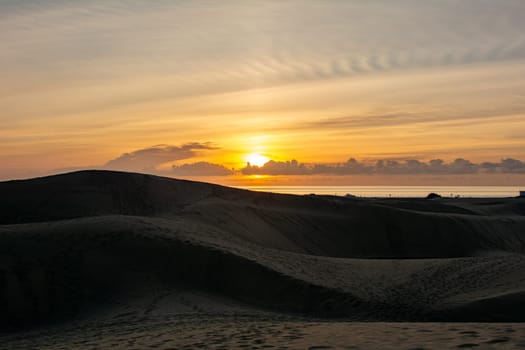 In the dunes of Maspalomas at sunrise on Gran Canaria in Spain. The huge sand dunes resemble a small desert and are a nature reserve.