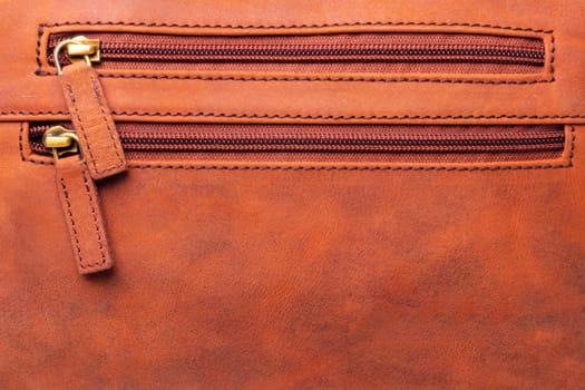 Zip fastener background texture. A high-resolution closeup of a detail from two closed plastic zip fastening on brown leather handbag. Macro photo.