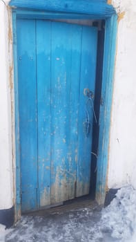 old rustic door in village, snow in road. High quality photo