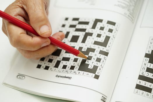 elderly woman playing sudoku puzzle game for treatment dementia prevention and Alzheimer disease.