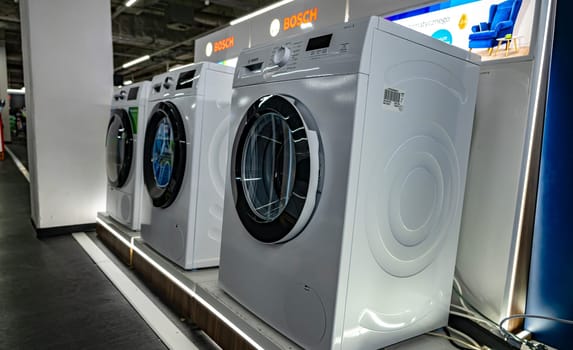 POZNAN, POL - DEC 8, 2023: Front-loader washing machines by Bosh put up for sale in a household goods store