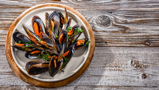 Composition with a plate of steamed mussels served with parsley and lemon