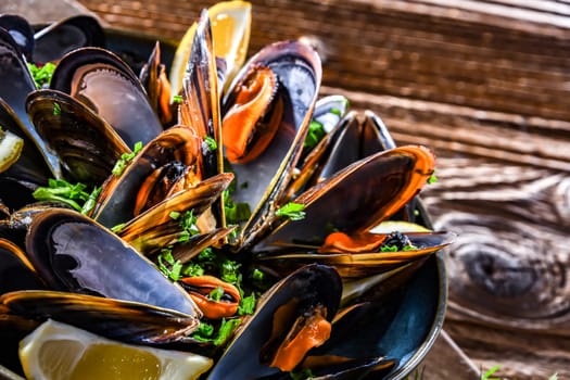 Composition with a plate of steamed mussels served with parsley and lemon