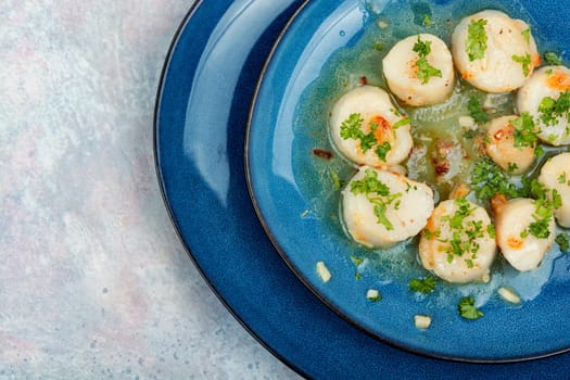 Fried delicious scallops with green on a plate
