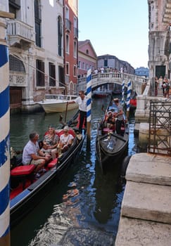 Venice, Italy - September 5, 2022: One of the most recognizable tourist attractions in the world - a gondola cruise through the narrow canals in Venice