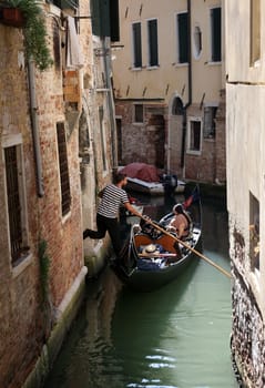 Venice, Italy - September 5, 2022: One of the most recognizable tourist attractions in the world - a gondola cruise through the narrow canals in Venice