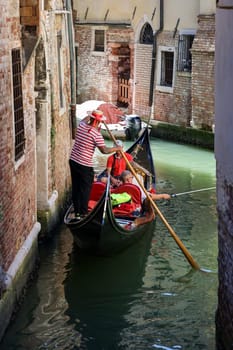 Venice, Italy - September 5, 2022: One of the most recognizable tourist attractions in the world - a gondola cruise through the narrow canals in Venice