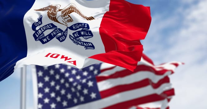 Iowa state flag waving in the wind with the American national flag on a clear day. 3d illustration render. Rippled fabric