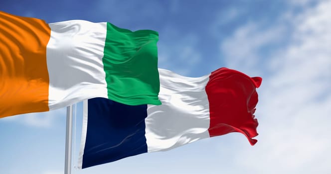 Ivory Coast and France national flags waving in the wind on a clear day symbolizing the Franco-Ivorian friendship and shared cultural heritage. 3d illustration render. Fluttering fabric