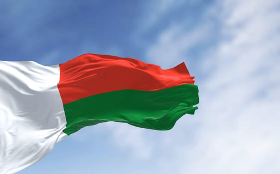 National flag of Madagascar waving in the wind on a clear day. Two horizontal bands of red and green, with a white vertical band on the left. 3d illustration render. Rippling fabric