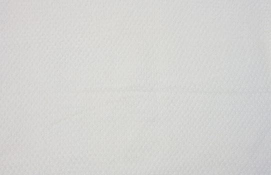 Fragment of a white knitted sweater, close up
