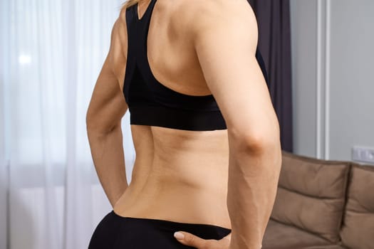 Muscular female body of middle-aged woman in sportswear