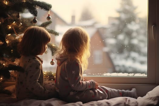 Christmas time. Children sitting by window waiting for first snow. Kids looking at Christmas tree and snowman outside. Christmas Eve. The Star of Bethlehem. Waiting for Santa Claus. Christmas holiday. Silent night. Winter holiday