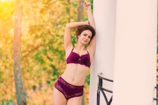 Beautiful young woman in lingerie posing in autumn forest