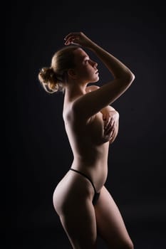 Low key portrait of beautiful female body on a dark background