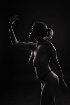Low key portrait of beautiful female body on a dark background