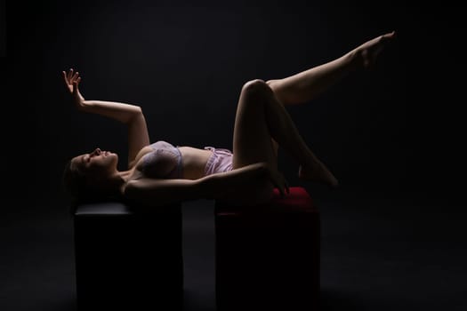 Low key portrait of beautiful female body on a dark background