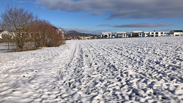 winter in Germany, acre with snow cap, hill and houses