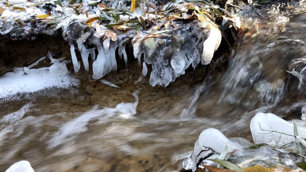 little creek in winter with icicles