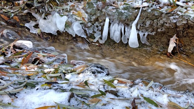 little creek in winter with icicles