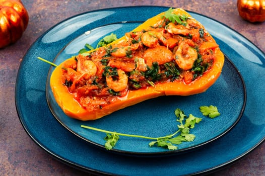 Roasted autumn butternut squash or pumpkin stuffed with peppers, tomatoes and shrimp.