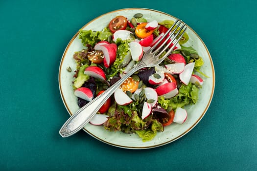 Easy salad with radish, greens, tomato and sesame. Food for vegetarians.