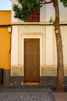 Old wooden door on a house with a tree on the Canary Island of Gran Canaria in Spain