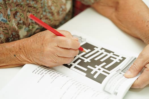 elderly woman playing sudoku puzzle game for treatment dementia prevention and Alzheimer disease.