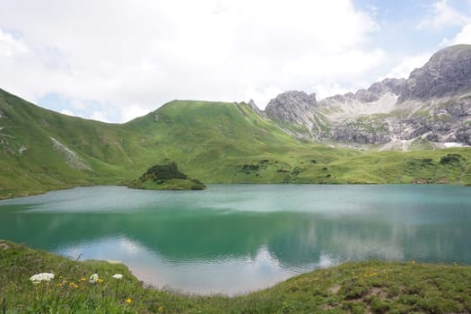 The beautiful lake Schrecksee in the german Alps with its Island and surrounding mountains, Allgäu, Germany 2020