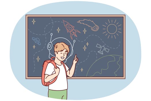 Joyful boy with backpack behind back stands near blackboard depicting universe with spaceships and planets. Schoolboy is fond of astronomy with drawings of UFOs and satellite ships. Flat vector image
