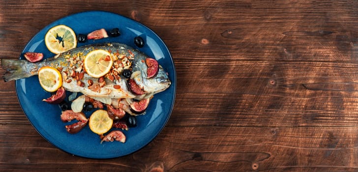 Baked dorado fish with almonds and figs. Autumn recipe. Space for text