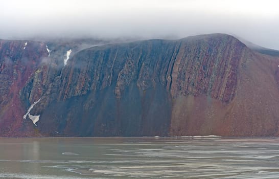 Dramatic Cliffs On An Arctic Fjord at Lomfjorden in the Svalbard Islands